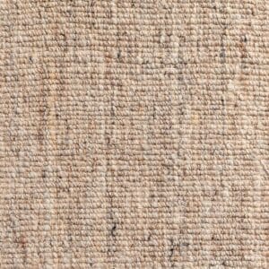 Vista ravvicinata di un tessuto beige con una superficie leggermente ruvida e irregolare, che mostra piccole variazioni di colore e spessore della fibra simili a lentiggini.