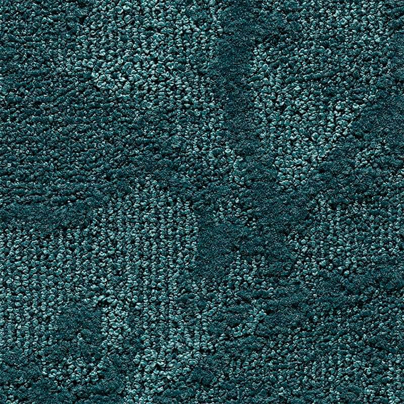 Una vista ravvicinata di un tappeto testurizzato di colore verde acqua con un motivo ad anello in rilievo e sottili variazioni di ombreggiatura, che crea un senso di profondità e un disegno geometrico astratto che ricorda Bozza automatica.